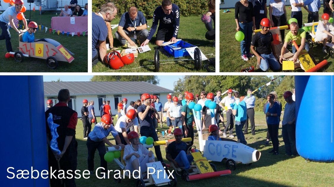 Billedet viser den sjove teambuildingaktivitet Sæbekasse Grand Prix, hvor deltagerne i hold bygger og dekorerer deres egne sæbekassebiler. Iført hjelme og godt humør dyster de i kreativitet, samarbejde og fart – alt sammen i en festlig og farverig stemning udendørs.